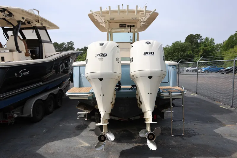Slide: The Image of 2018 Scout 300 LXF boat with dual Yamaha 300 engines, parked in a marina. - 4