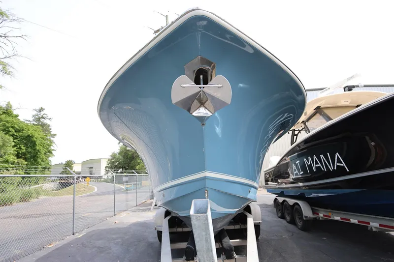 Slide: The Image of 2018 Scout 300 LXF boat on trailer, blue hull, parked outdoors. - 7