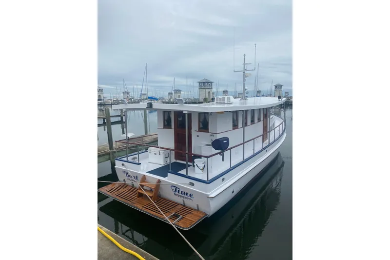 Slide: The Image of 1996 Bill Holland trawler docked at a marina, featuring a classic design and wooden accents. - 11