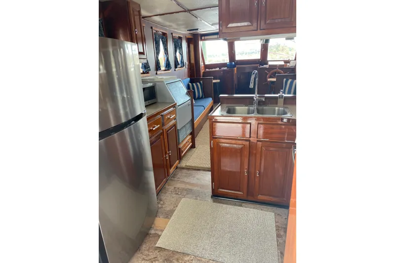 Slide: The Image of Interior of a 1996 Bill Holland trawler with wooden cabinetry and modern kitchen amenities. - 9