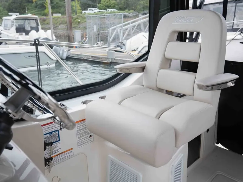 Slide: The Image of Interior of 2026 Boston Whaler 325 Conquest with luxurious captain's chair. - 11