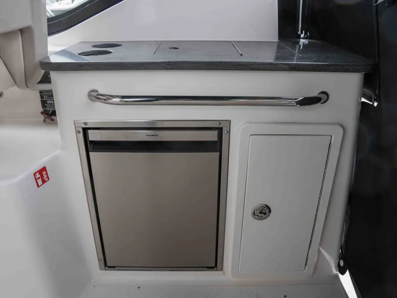 Slide: The Image of Interior of 2026 Boston Whaler 325 Conquest with fridge and storage. - 14