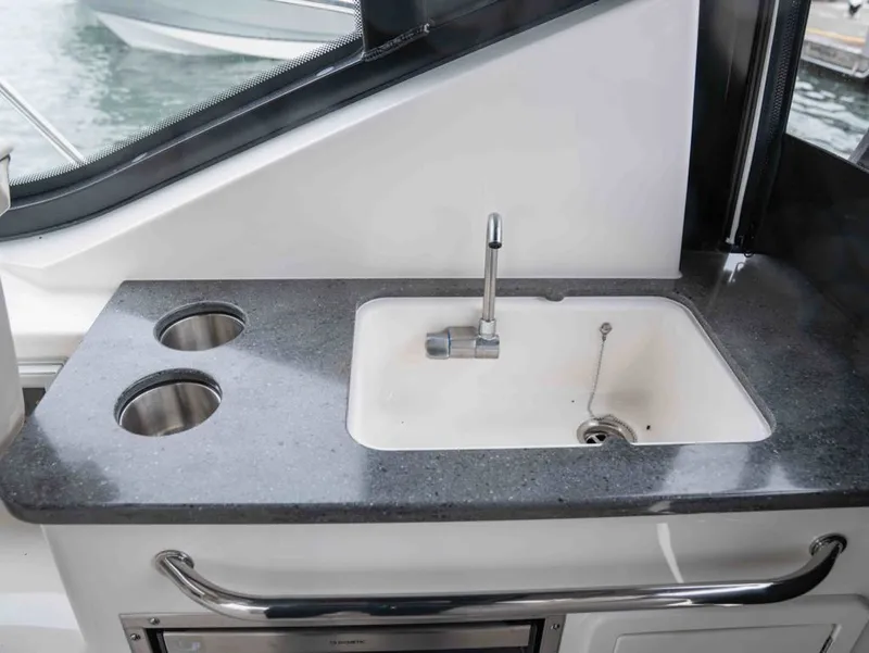 Slide: The Image of Boston Whaler 325 Conquest 2026: Modern kitchenette with sink and cup holders. - 15