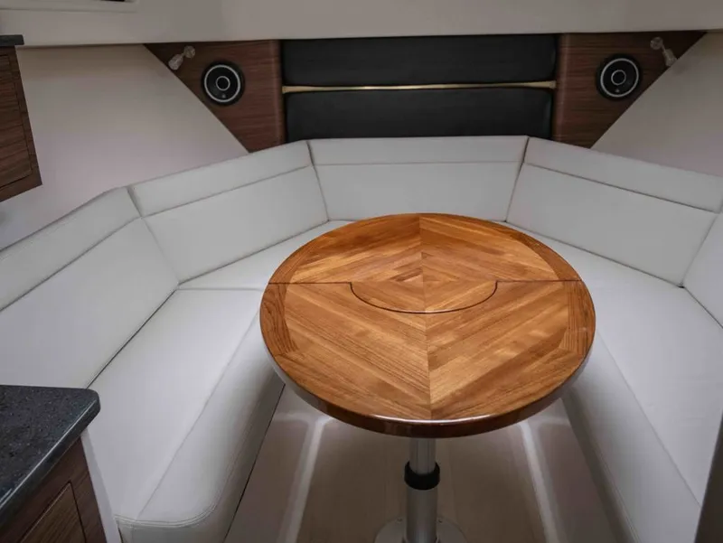 Slide: The Image of Interior of 2026 Boston Whaler 325 Conquest with wooden table and white seating. - 17