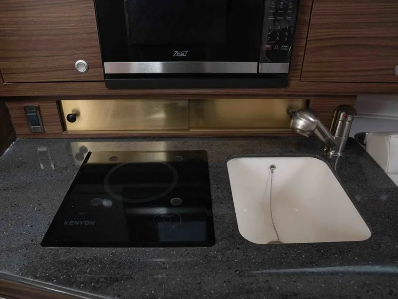 Slide: The Image of Boston Whaler 325 Conquest 2026 kitchen area with stove and sink. - 21