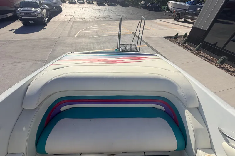 Slide: The Image of 1999 Baja 29 Outlaw boat with colorful seating, parked outdoors on a sunny day. - 15