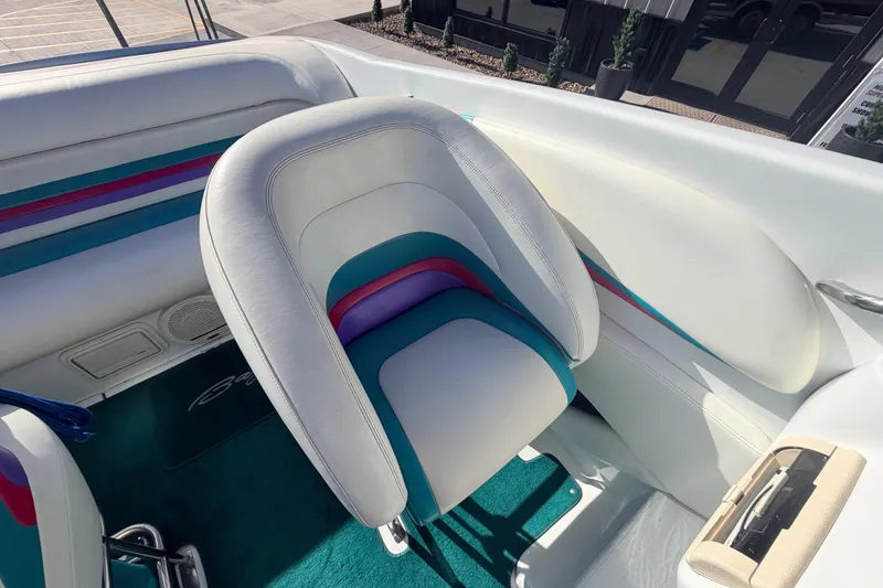 Slide: The Image of 1999 Baja 29 Outlaw boat interior with colorful seating and teal carpet. - 16