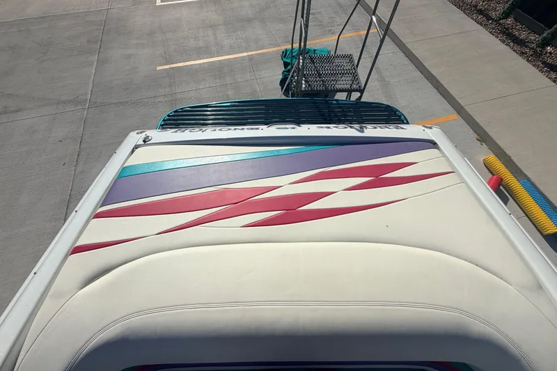 Slide: The Image of 1999 Baja 29 Outlaw boat with colorful deck design in a parking area. - 20