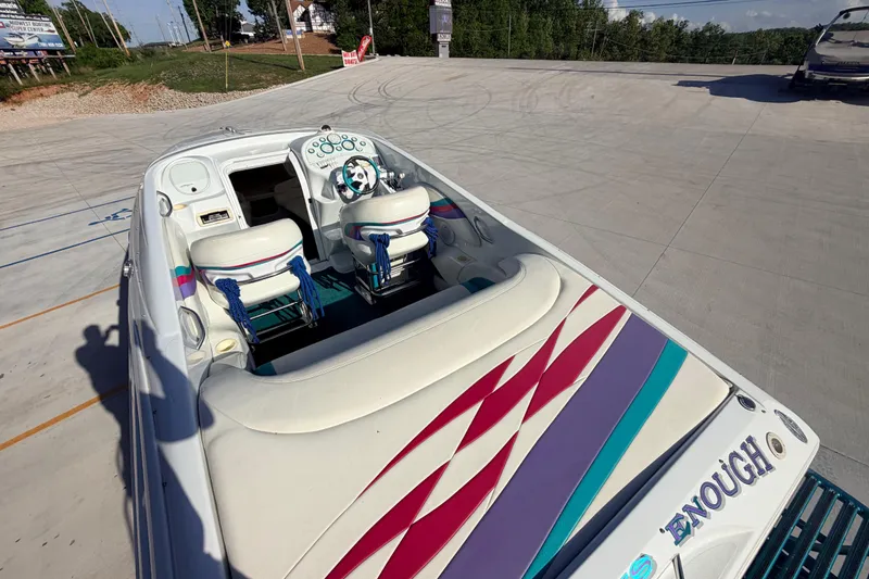 Slide: The Image of 1999 Baja 29 Outlaw boat with colorful interior design, parked on concrete surface. - 21