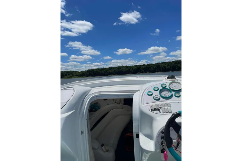 Slide: The Image of 1999 Baja 29 Outlaw boat interior with dashboard, under a clear blue sky. - 24