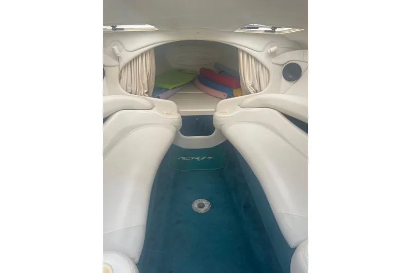 Slide: The Image of Interior of a 1999 Baja 29 Outlaw boat with white seating and blue carpet. - 27