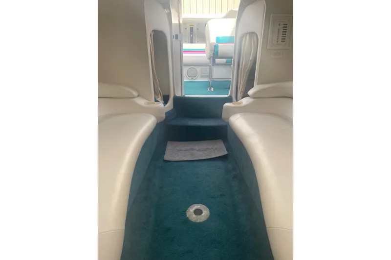 Slide: The Image of Interior of a 1999 Baja 29 Outlaw boat with white seating and teal carpet. - 29
