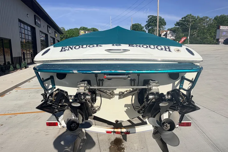 Slide: The Image of 1999 Baja 29 Outlaw boat with "Enough is Enough" text on the stern, parked outdoors. - 3