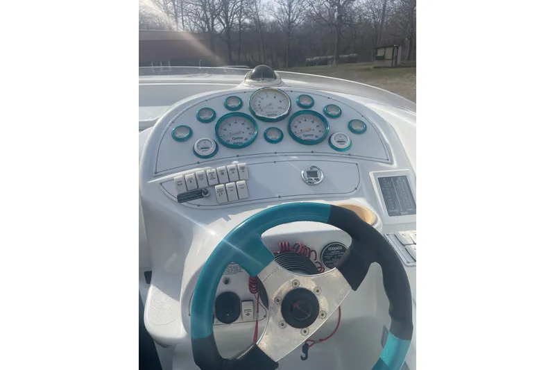 Slide: The Image of Dashboard of a 1999 Baja 29 Outlaw boat with gauges and steering wheel. - 30