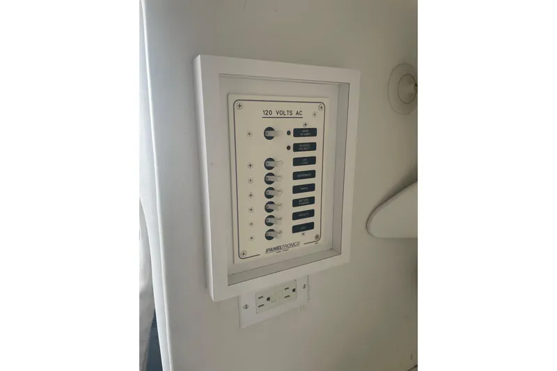 Slide: The Image of Electrical panel on a 1999 Baja 29 Outlaw boat, featuring 120 volts AC switches. - 31