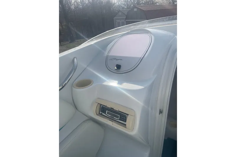 Slide: The Image of Interior view of a 1999 Baja 29 Outlaw boat, featuring dashboard and cup holder. - 32