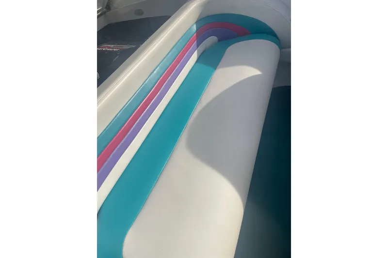 Slide: The Image of 1999 Baja 29 Outlaw boat interior with colorful striped seating design. - 35