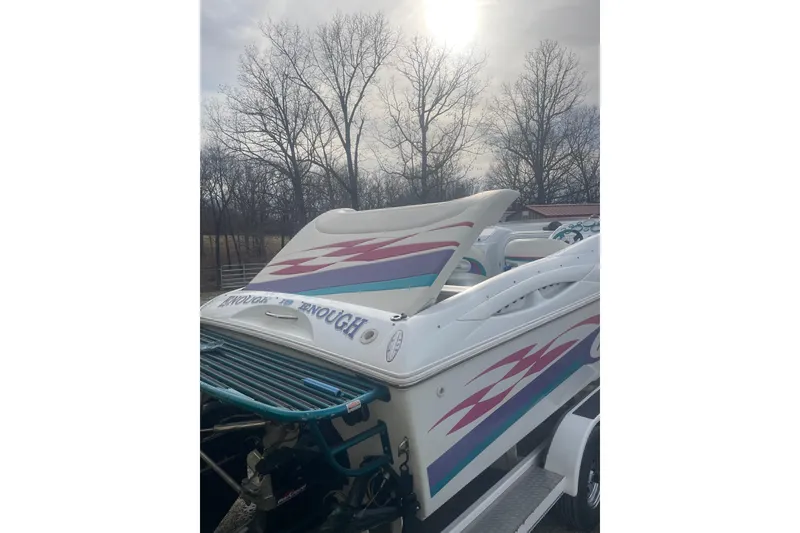 Slide: The Image of 1999 Baja 29 Outlaw speedboat with vibrant graphics, parked outdoors under a cloudy sky. - 37