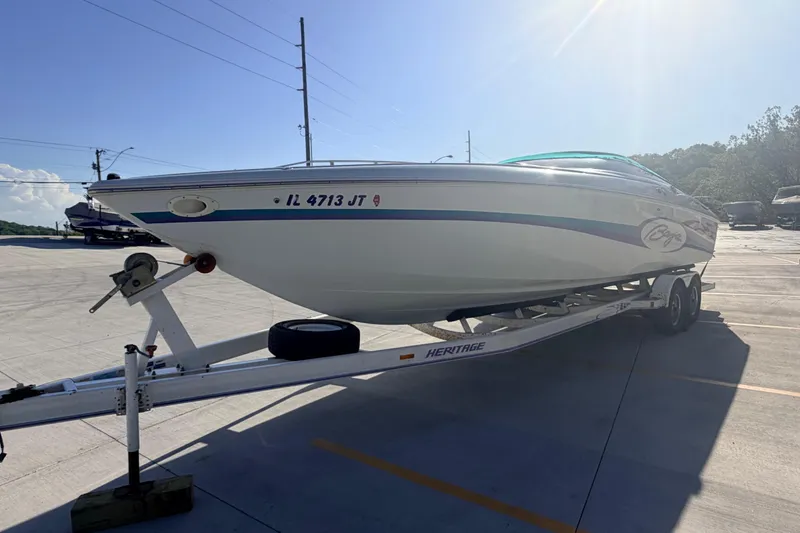 Slide: The Image of 1999 Baja 29 Outlaw boat on trailer in sunny parking lot. - 7