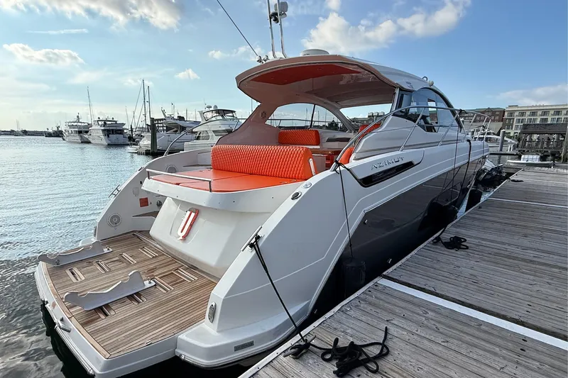 Slide: The Image of 2016 Azimut Atlantis 43 yacht docked, featuring sleek design and vibrant orange seating. - 11