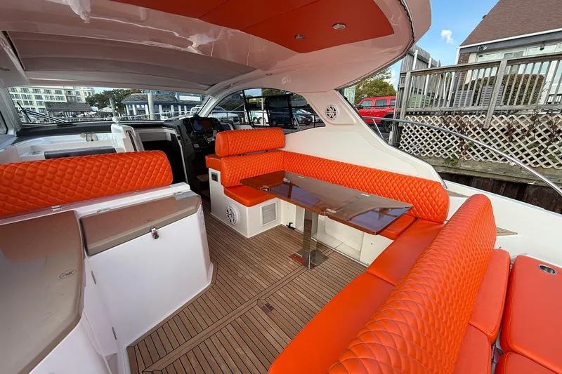 Slide: The Image of 2016 Azimut Atlantis 43 yacht interior with vibrant orange seating and sleek wooden flooring. - 16