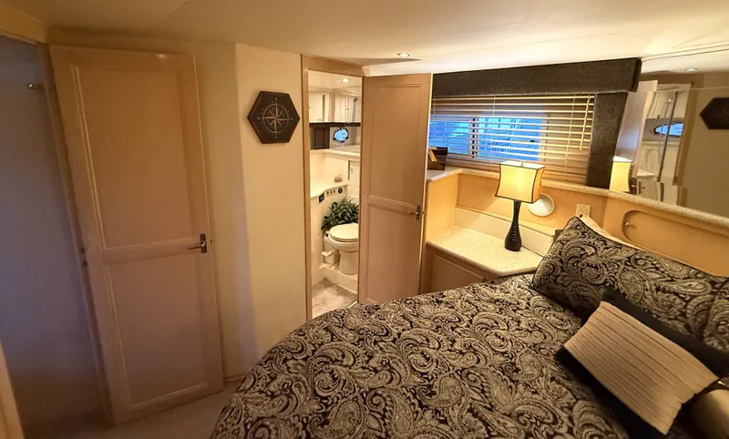 Slide: The Image of Interior of a 1999 Carver 406 yacht featuring bedroom and bathroom. - 25