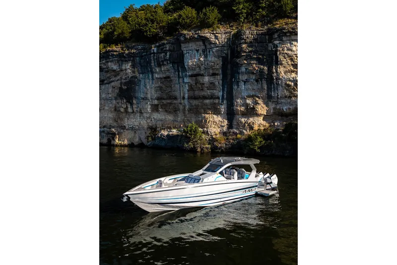 The Image of Modern AMP 433 boat on calm water near rocky cliff, 2026 model. - 1