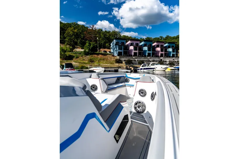 Slide: The Image of Modern AMP 433 boat interior with speakers, docked near colorful waterfront houses, under a blue sky. - 16