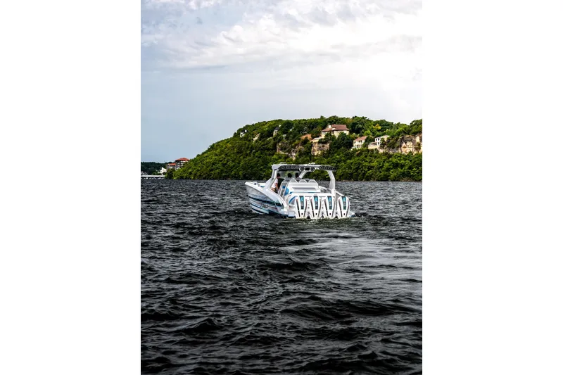 Slide: The Image of A modern AMP 433 boat on a scenic lake with lush green hills in the background. - 5