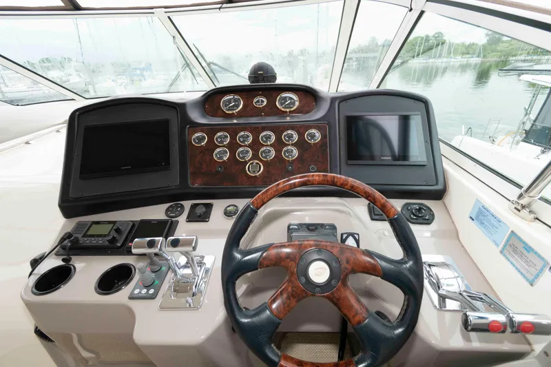 Slide: The Image of Cockpit of 2003 Cruisers Yachts 4050 Express with steering wheel and control panels. - 12