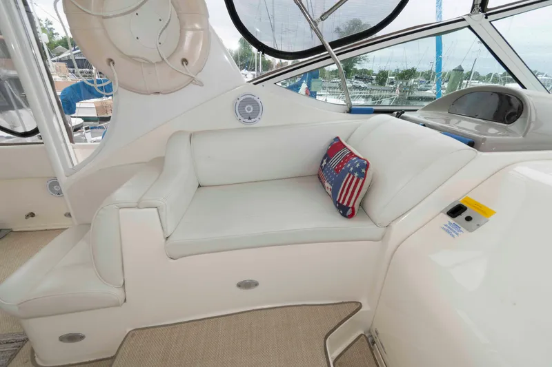 Slide: The Image of 2003 Cruisers Yachts 4050 Express interior with white seating and American flag pillow. - 14