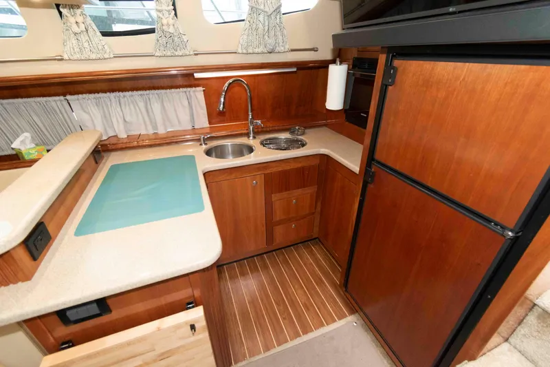 Slide: The Image of 2003 Cruisers Yachts 4050 Express kitchen with wood cabinetry and modern appliances. - 18