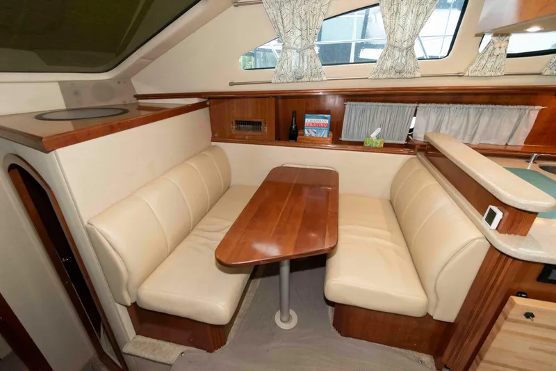 Slide: The Image of 2003 Cruisers Yachts 4050 Express interior with cozy dining area and wooden table. - 19