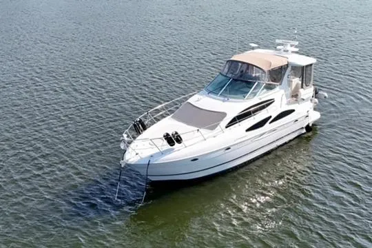 Slide: The Image of 2003 Cruisers Yachts 4050 Express on calm water, showcasing sleek design and luxury features. - 2