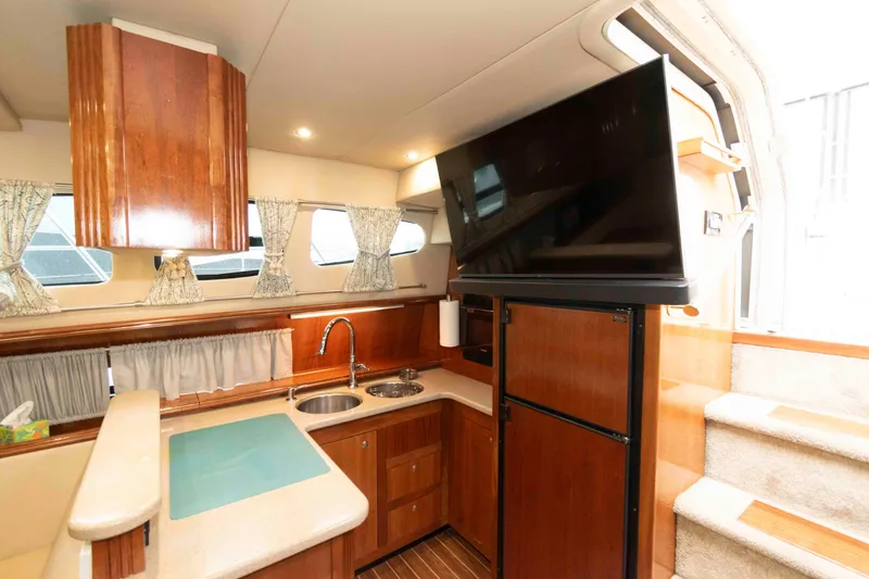 Slide: The Image of Interior of 2003 Cruisers Yachts 4050 Express, featuring a modern kitchen and entertainment area. - 21