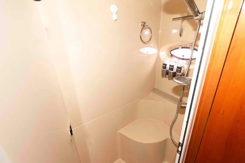 Slide: The Image of Shower area in 2003 Cruisers Yachts 4050 Express, featuring modern fixtures and porthole window. - 27