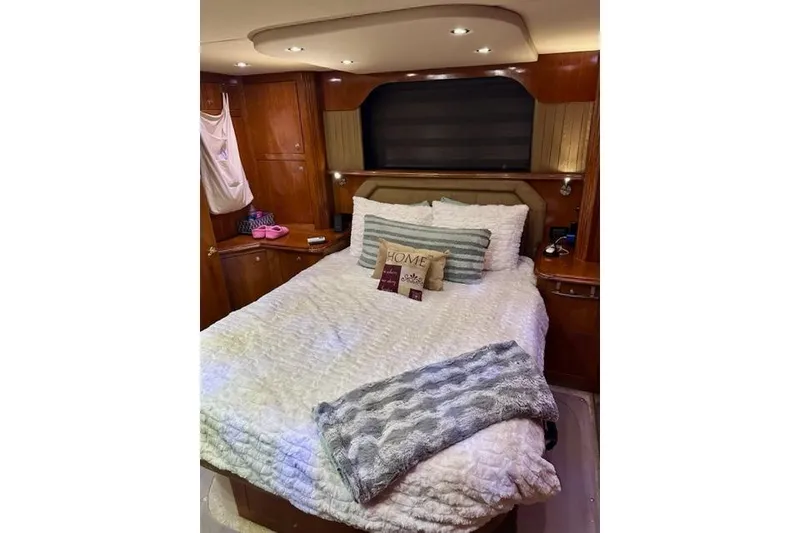 Slide: The Image of Luxurious bedroom interior of 2003 Cruisers Yachts 4050 Express with cozy bedding and wooden accents. - 4