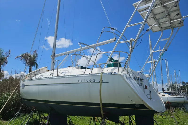 Slide: The Image of 1997 Beneteau Oceanis Clipper 321 sailboat named "Moxie" with lush greenery background. - 10