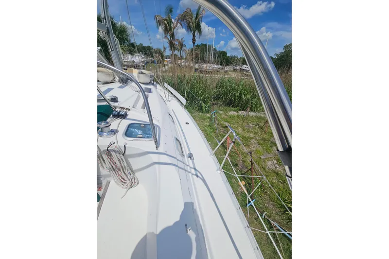 Slide: The Image of Interior of 1997 Beneteau Oceanis Clipper 321 with blue cushioned seating and wooden accents. - 17
