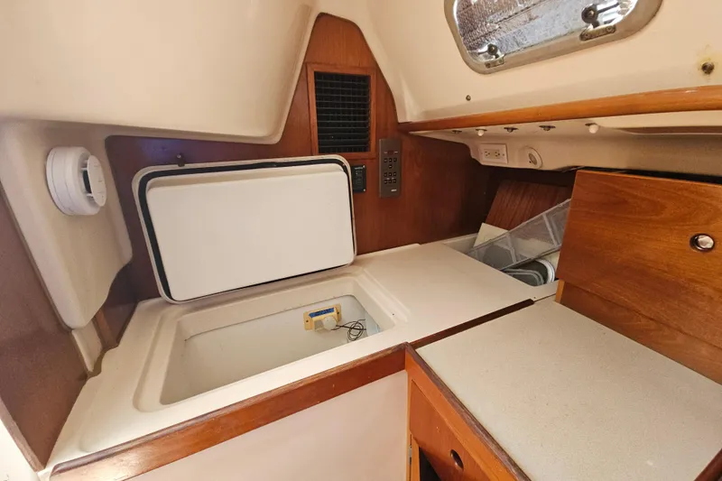 Slide: The Image of Interior of 1997 Beneteau Oceanis Clipper 321 sailboat, featuring a compact kitchen area. - 25
