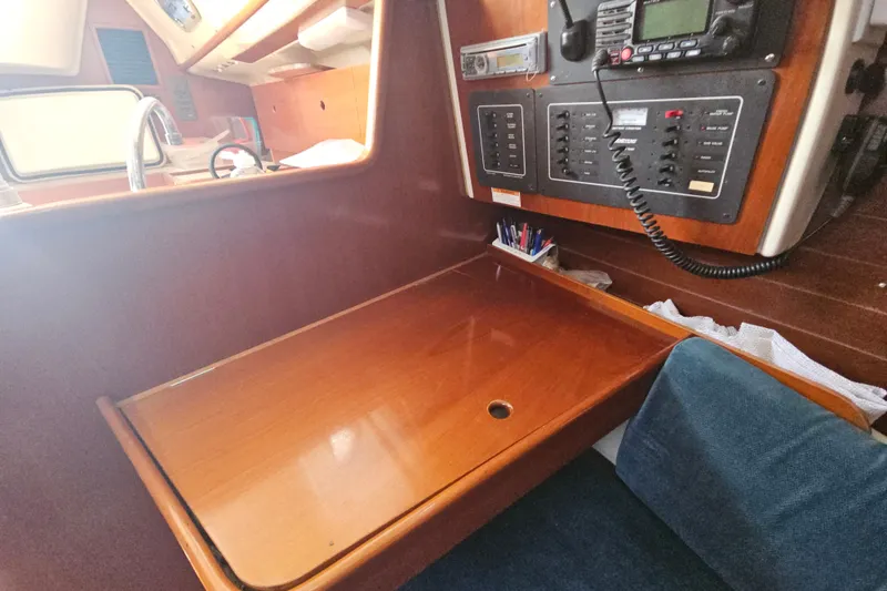 Slide: The Image of Interior of 1997 Beneteau Oceanis Clipper 321 sailboat with wooden table and blue seating. - 27
