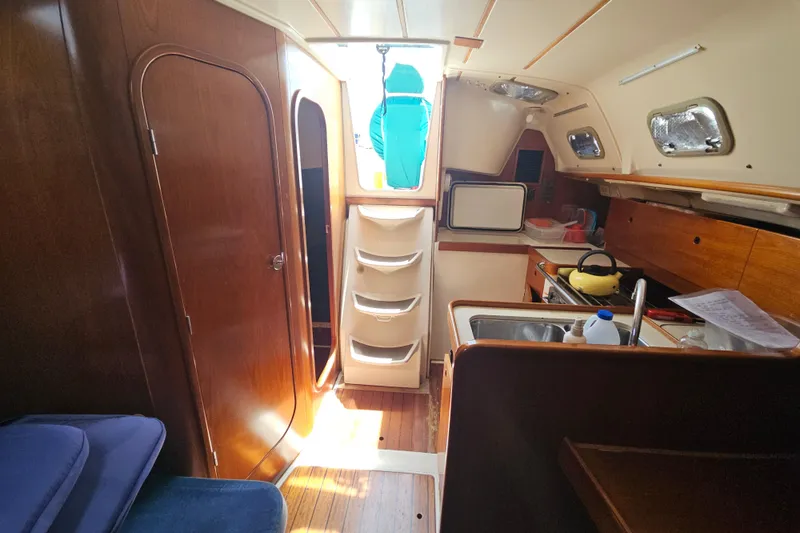Slide: The Image of Interior of 1997 Beneteau Oceanis Clipper 321 sailboat with wooden table and blue seating. - 28