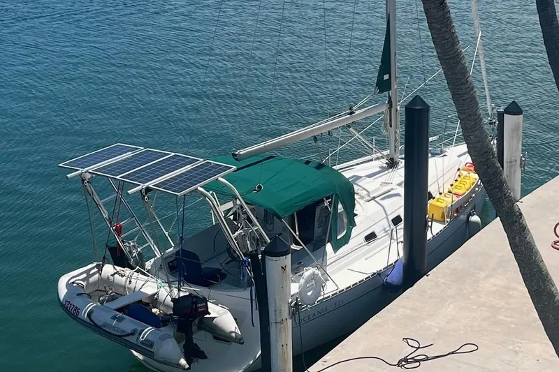 Slide: The Image of 1997 Beneteau Oceanis Clipper 321 sailboat on land, named "Moxie," under a sunny sky. - 6