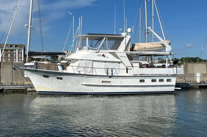 The Image of 1998 DeFever 44 Sundeck Trawler docked at marina under clear blue sky. - 0