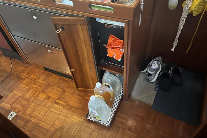 Slide: The Image of Interior of 1998 DeFever 44 Sundeck Trawler with wooden flooring and storage area. - 10