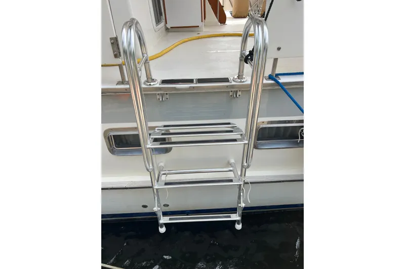 Slide: The Image of Stainless steel ladder on 1998 DeFever 44 Sundeck Trawler, docked by water. - 3