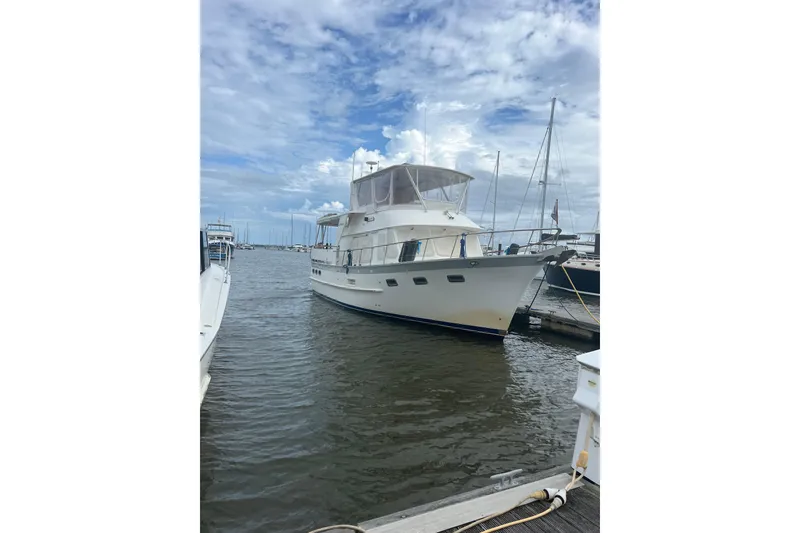 Slide: The Image of 1998 DeFever 44 Sundeck Trawler docked at marina under cloudy sky. - 4