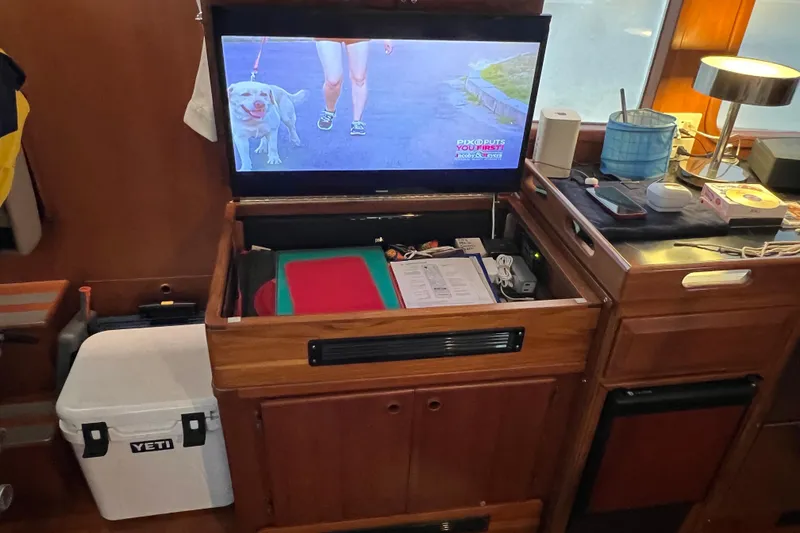 Slide: The Image of Interior of 1998 DeFever 44 Sundeck Trawler with TV, storage, and Yeti cooler. - 6