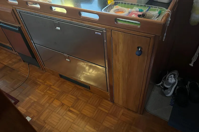 Slide: The Image of Interior of 1998 DeFever 44 Sundeck Trawler with wooden cabinetry and stainless steel drawers. - 9