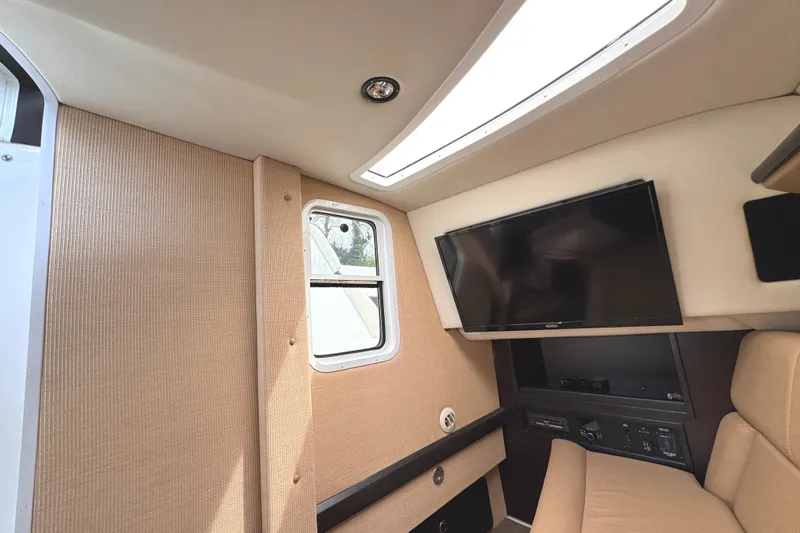 Slide: The Image of Interior of 2018 Cobalt R35 boat with TV, window, and beige seating. - 40